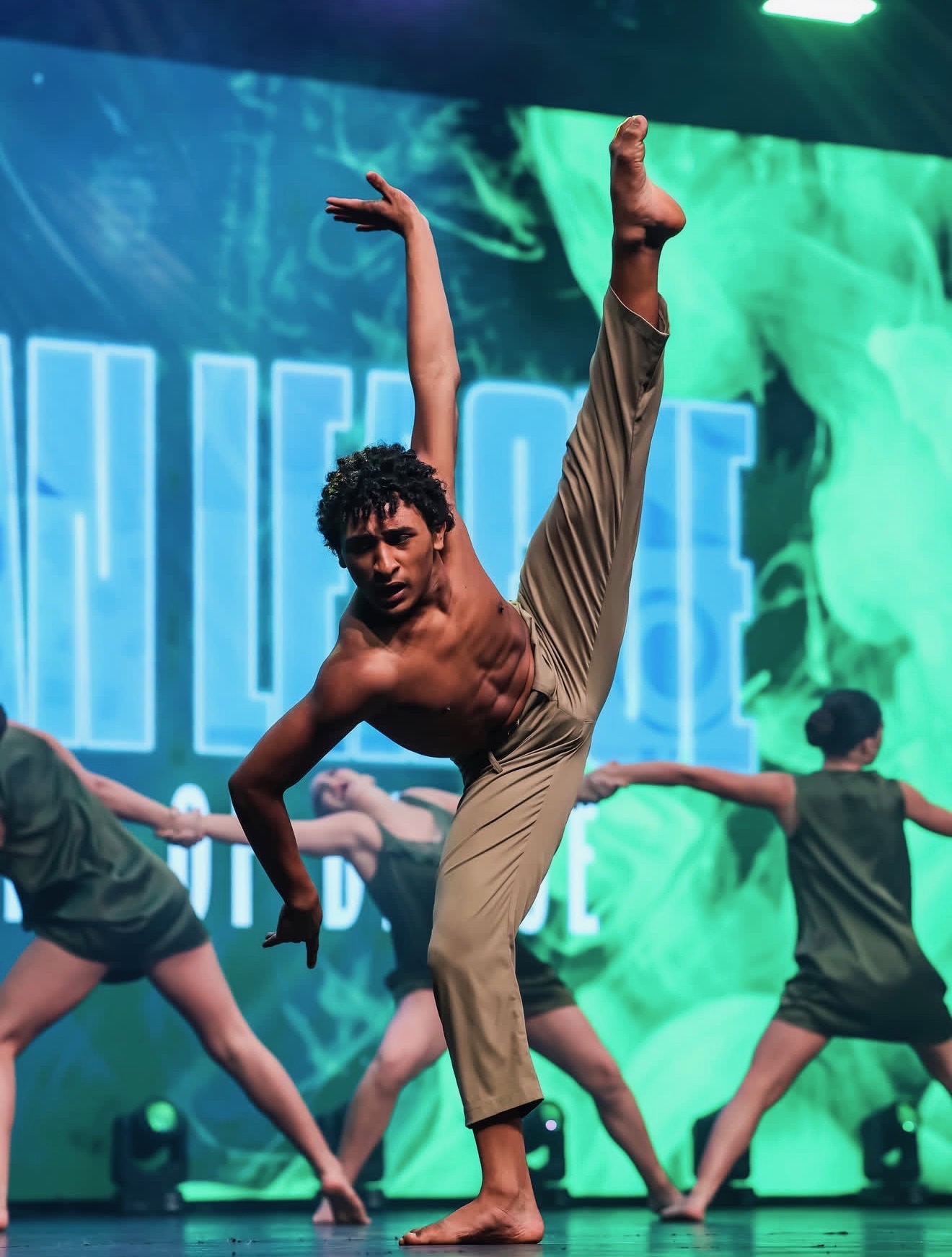 Contemporary soloist mid-extension under green lights